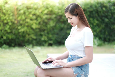 Side view of woman using mobile phone