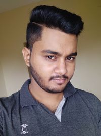 Close-up portrait of young man against wall