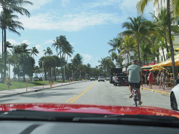 Rear view of people on street against sky