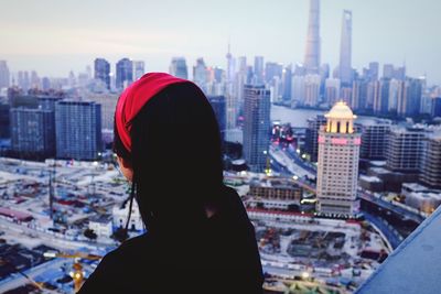 Rear view of woman against cityscape