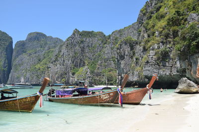 Boats moored on sea against clear sky