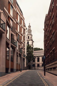 Street amidst buildings against sky in city