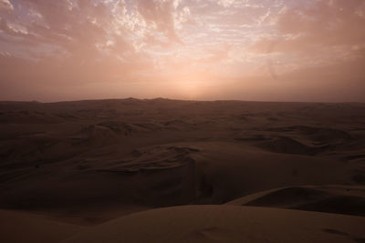 Scenic view of desert against sky during sunset