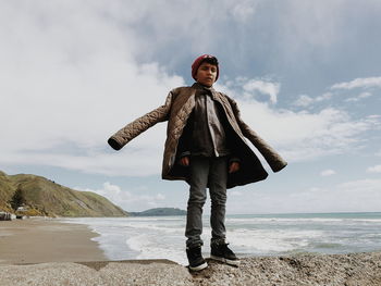 Full length of man standing at beach against sky