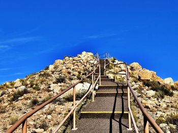 Low angle view of steps against clear blue sky