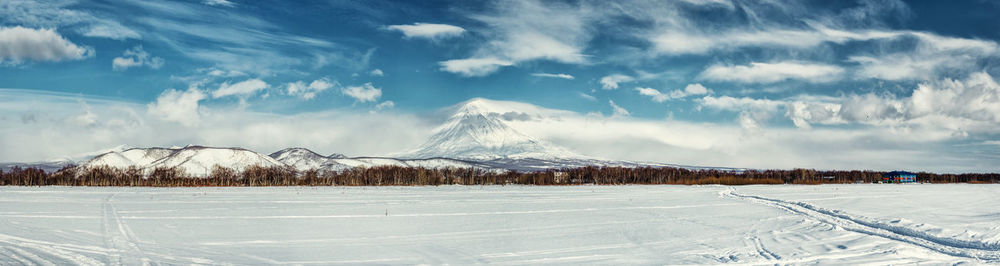 Panoramic view of snow covered landscape against sky