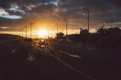 Traffic on road at sunset