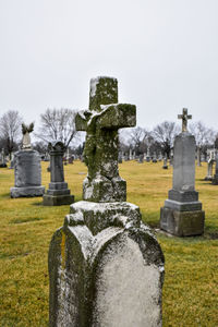 Tombstones in cemetery against clear sky