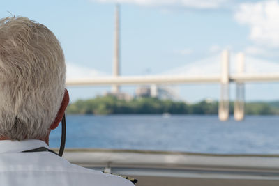 Rear view of man looking at sea against sky