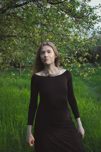 Woman wearing tight-fitting black dress in garden scenic photography