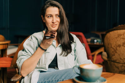 Portrait of young woman using mobile phone