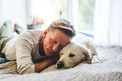 Dog lying on man relaxing at home