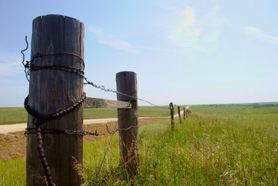 View of wooden fence on field against sky