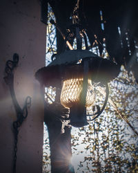 Low angle view of illuminated lamp hanging on wall