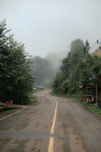 Road amidst trees against sky