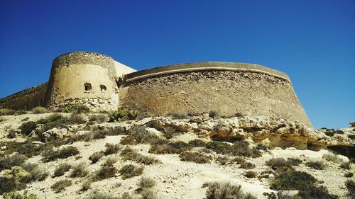 Low angle view of castle against clear blue sky