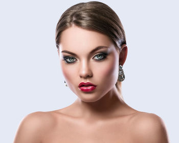 Close-up portrait of young woman against white background