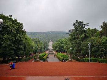 View of trees and plants against cloudy sky