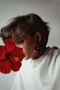 Close-up portrait of teenage girl with red flower