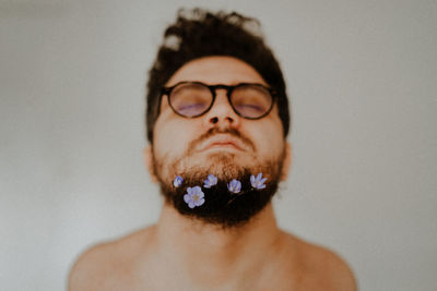 Portrait of young man wearing eyeglasses against white background