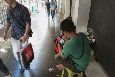 Rear view of man walking on tiled floor