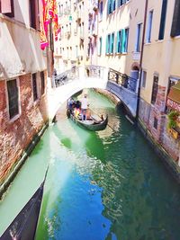 High angle view of boats in canal amidst buildings