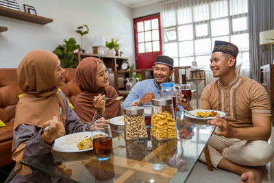 Smiling friends having dessert at home