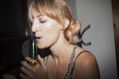 Young women enjoying a beer at a party