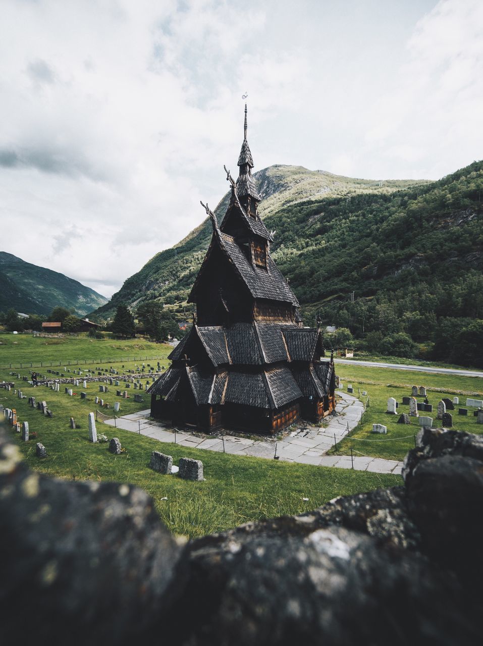 spirituality, religion, cemetery, day, grass, no people, the past, architecture, sky, memorial, place of worship, history, outdoors, built structure, old ruin, landscape, field, cloud - sky, nature, tree, mountain, building exterior, graveyard, gravestone, scenics