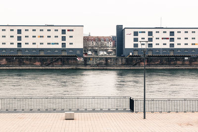 Scenic view of river in city against clear sky