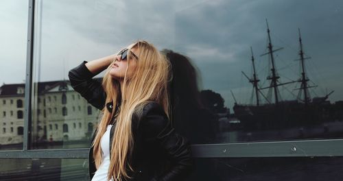 Young woman against sky