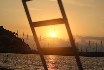 Silhouette sailboats on sea against sky during sunset