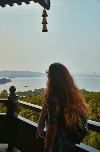 Woman looking at view while standing on balcony