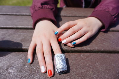 Cropped hands of woman with colorful painted nail