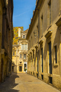 Street amidst buildings in town against sky