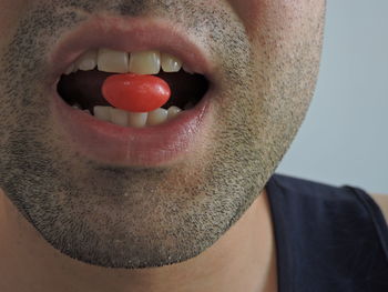 Close-up of man eating red candies