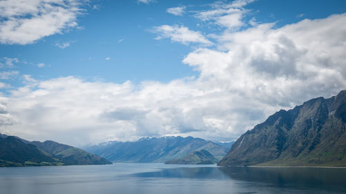 Scenic alpine lake surrounded by mountains shot on sunny day. location is lake hawea, new zealand.