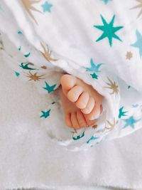 High angle view of baby feet on bed