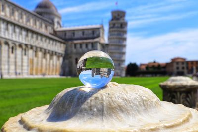 Close-up of crystal ball on glass against building