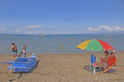 Boats on beach against blue sky