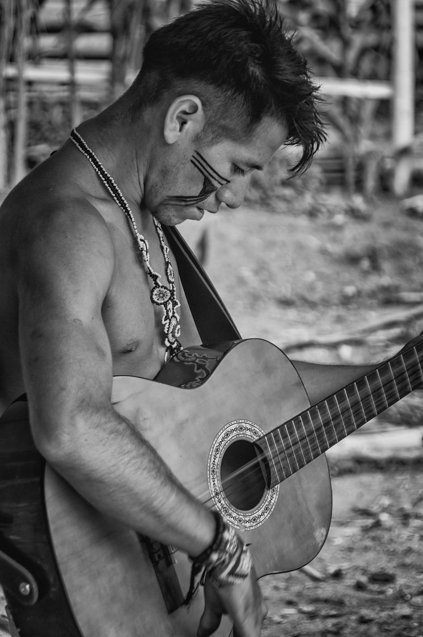 playing, guitar, music, musical instrument, plucking an instrument, outdoors, musician, one person, leisure activity, arts culture and entertainment, performance, skill, real people, lifestyles, musical instrument string, electric guitar, day, men, young adult, one man only, only men, adult, adults only, people