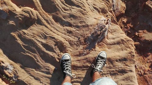 Low section of man standing on rock