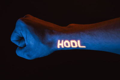 Close-up of human hand against black background