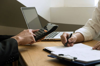 Midsection of man using laptop on table