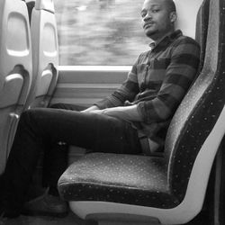 Man sitting on seat in bus