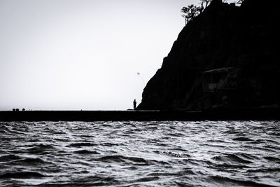 Man in sea against clear sky