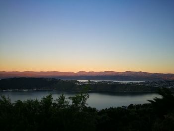 Scenic view of lake against clear sky at sunset