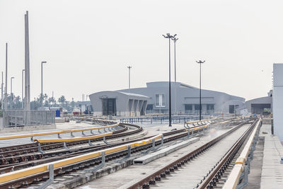 Railroad tracks in city against clear sky