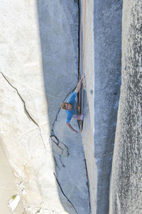 Rock climbing clipping rock while lead climbing the nose on el capitan