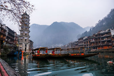 Boats in river with city in background